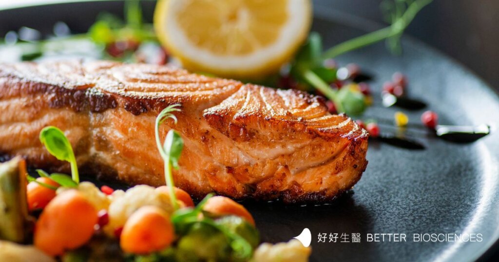 煎熟的鮭魚放在盤子上，旁邊放上配菜及佐料