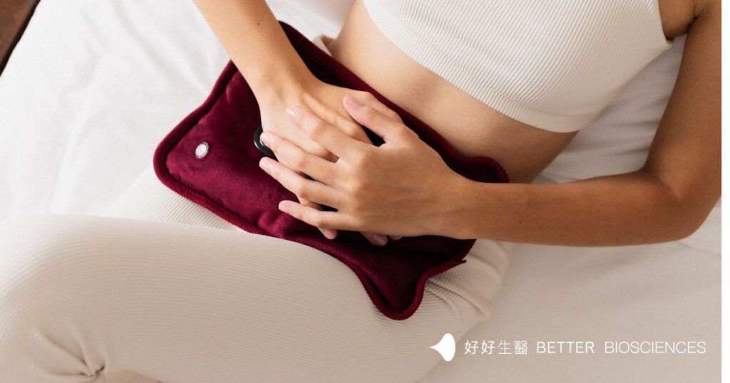 一名穿著白色長褲的女性以手扶著腹部。