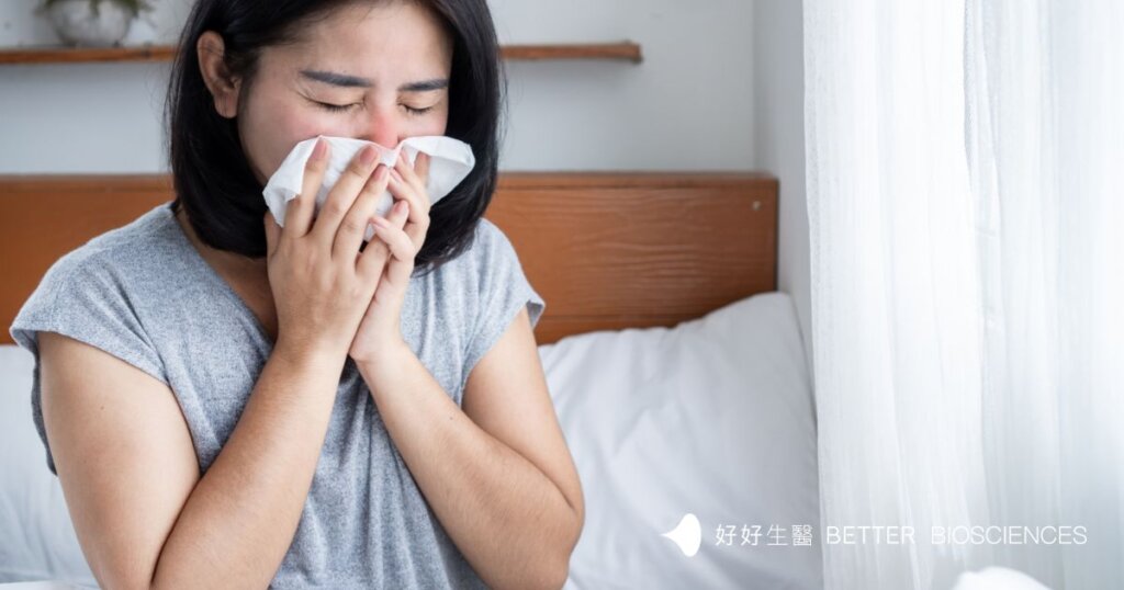  一名女性坐在床上用衛生紙擤鼻子，呈現感冒不適的情境。